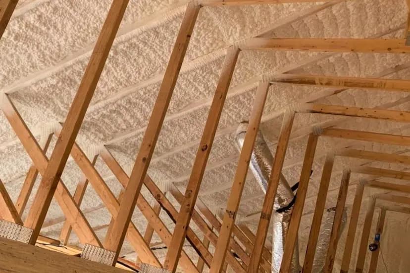 Closed-cell spray foam sealing a building's roof deck between the rafters